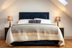 a bedroom with a large bed with two lamps at The Studio in Castle Bytham