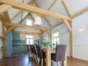 a dining room with a wooden table and chairs at Spacious farmhouse in wooded area in Zuidoostbeemster
