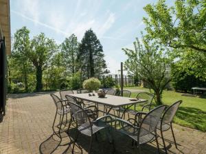 una mesa y sillas en un patio de ladrillo en Spacious farmhouse in wooded area, en Zuidoostbeemster