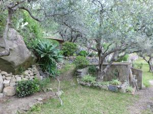 a garden with trees and a stone wall at Villa Artemis in Graniti