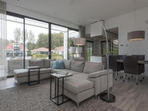 uma sala de estar com um sofá e uma mesa em Luxury villa with private jetty in quiet park em Zeewolde