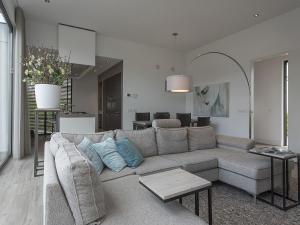 a living room with a couch and a table at Luxury villa with private jetty in quiet park in Zeewolde