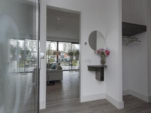 a living room with a mirror on the wall at Luxury villa with private jetty in quiet park in Zeewolde