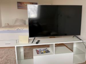 a flat screen tv on a white entertainment center at 1,5 Zimmer Apartment, 38,5 qm, Multimedia TV, Uni, HBF in Duisburg