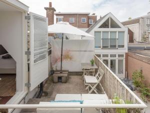 a balcony with a table and an umbrella at Picturesque fisherman s house near the beach in Scheveningen