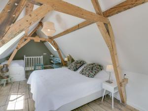 a bedroom with a white bed and wooden beams at Picturesque fisherman s house near the beach in Scheveningen