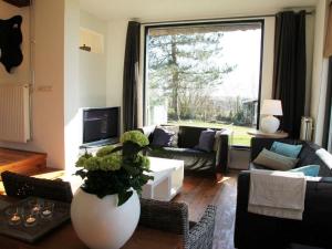 een woonkamer met een bank en een groot raam bij Luxurious Mansion in Callantsoog with Sauna in Julianadorp