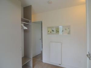 a room with a white wall and a white radiator at Forest Retreat Near Kempen-Broek in De Horst