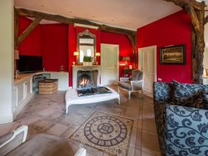 sala de estar con chimenea y paredes rojas en Country house in nature en Oldenzaal