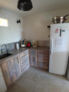 cocina con nevera blanca y armarios de madera en Gîte Pilpoil, en Sault-de-Vaucluse