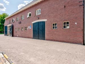 un gran edificio de ladrillo rojo con dos juegos de puertas en Restful Holiday Home with a Private Terrace and hottub, en Veendam