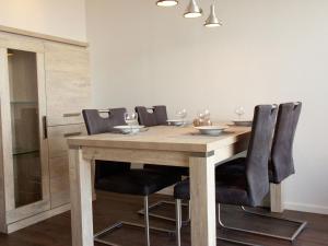 une salle à manger avec une table en bois et des chaises noires dans l'établissement Charming Apartment in Langweer with Jetty, à Langweer