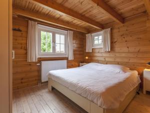 シント・アナラントにあるCosy wooden chalet with private gardenの木造家屋内のベッドルーム(ベッド付)