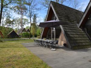 een patio met een tafel en een parasol bij Holiday home with large terrace in Stramproy