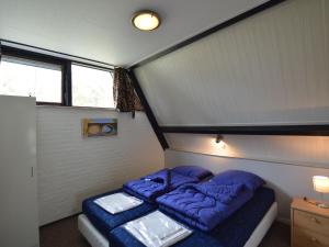 een kleine slaapkamer met 2 bedden in een kamer bij Holiday home with large terrace in Stramproy