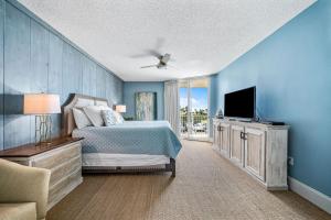 um quarto azul com uma cama e uma televisão em Newly Updated Caribe 213B em Orange Beach