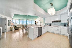 uma grande cozinha com armários brancos e um tecto verde em Newly Updated Caribe 213B em Orange Beach