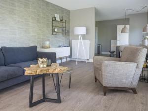 a living room with a couch and a table at Apartment in tasteful farmhouse in De Cocksdorp on the Wadden island of Texel in De Cocksdorp