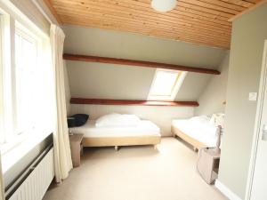 a room with two beds and a window at Nicely decorated villa with garden, near the sea in Hippolytushoef