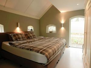 1 dormitorio con cama y ventana grande en Lovely Design Countryside Holiday Home en Haaksbergen