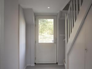 ハークスベルヘンにあるLovely Design Countryside Holiday Homeの白いドアと窓のある廊下