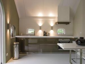 cocina con electrodomésticos de acero inoxidable y mesa en Lovely Design Countryside Holiday Home en Haaksbergen
