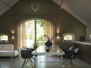 uma sala de estar com uma mesa branca e cadeiras em Lovely Design Countryside Holiday Home em Haaksbergen