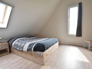 a bedroom with a wooden bed in a attic at Classy Villa in Tzummarum with Terrace Garden in Tzummarum