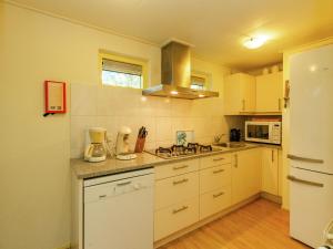 una cucina con armadietti bianchi e un frullatore sul bancone di Charming Holiday Home in Koudekerke Dishoek a Dishoek