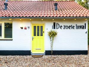 una casa con puerta amarilla y techo rojo en Charming Holiday Home in Koudekerke Dishoek, en Dishoek