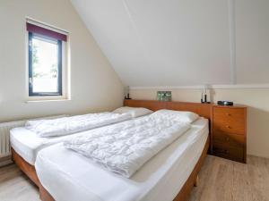 a bedroom with two beds and a dresser and a window at Serene Holiday Home in Gaasterl n Sleat in Sondel