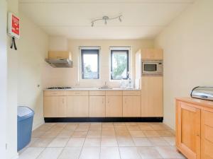 a kitchen with wooden cabinets and a sink at Serene Holiday Home in Gaasterl n Sleat in Sondel