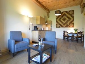 a living room with two blue chairs and a table at Pet-Friendly Getaway in Geesteren +27 photos