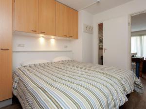 a bedroom with a bed and wooden cabinets at Apartment near the sea in Hollum in Hollum