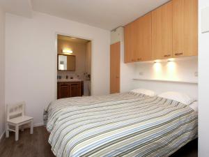 a bedroom with a bed and a small kitchen at Apartment near the sea in Hollum in Hollum