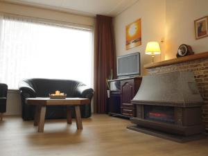 a living room with a fireplace and a couch at Quaint Holiday Home in Koewacht in Nieuwemolen