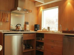 a kitchen with a stainless steel stove and a window at Holiday home for two people at a peaceful central location in Heiloo near Egmond in Heiloo
