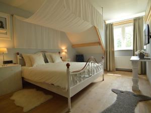 ein Schlafzimmer mit einem Himmelbett in der Unterkunft Holiday Home in Haaren near De Efteling in Haaren