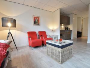 a living room with red chairs and a table at Apartment in Bergen near Sandy Beaches in Bergen