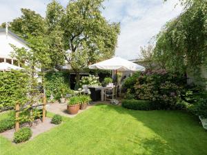 a garden with a table and an umbrella at Apartment in Bergen near Sandy Beaches in Bergen