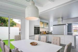 a kitchen and dining room with a white table and chairs at La Oliva Dreams luxury villa in La Oliva