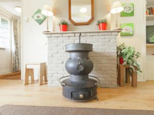 sala de estar con chimenea de ladrillo y fogones en Authentic holiday home near Baarn Utrecht on an estate, en Baarn