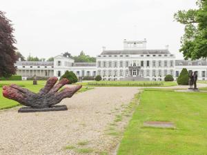 un gran edificio blanco con una estatua delante de él en Authentic holiday home near Baarn Utrecht on an estate, en Baarn