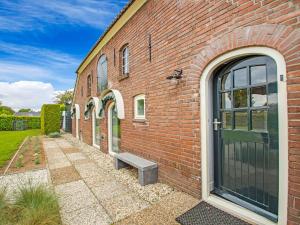 een bakstenen gebouw met een bank naast een deur bij Premium Farmhouse in Zelhem with Sauna in Zelhem