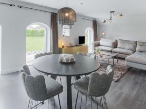 een woonkamer met een tafel en stoelen en een bank bij Premium Farmhouse in Zelhem with Sauna in Zelhem