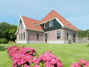 SchagerbrugにあるBeautiful holiday home in Schagerbrugの庭のピンクの花の家