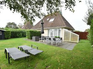 a backyard with tables and chairs and a house at Lush holiday home in Earnew ld in Earnewâld