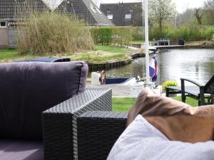 een paar banken op een patio bij een rivier bij Lush holiday home in Earnew ld in Earnewâld