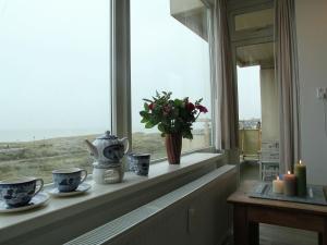ノールトウェイクにあるCosy apartment in Noordwijk aan Zee with balconyの花瓶とろうそく窓枠