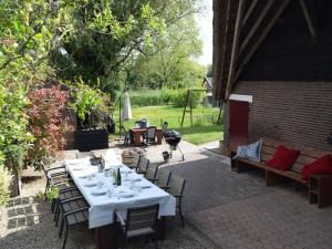 a patio with a table and chairs and a grill at Quaint Farmhouse near River in Oosterwijk in Leerdam